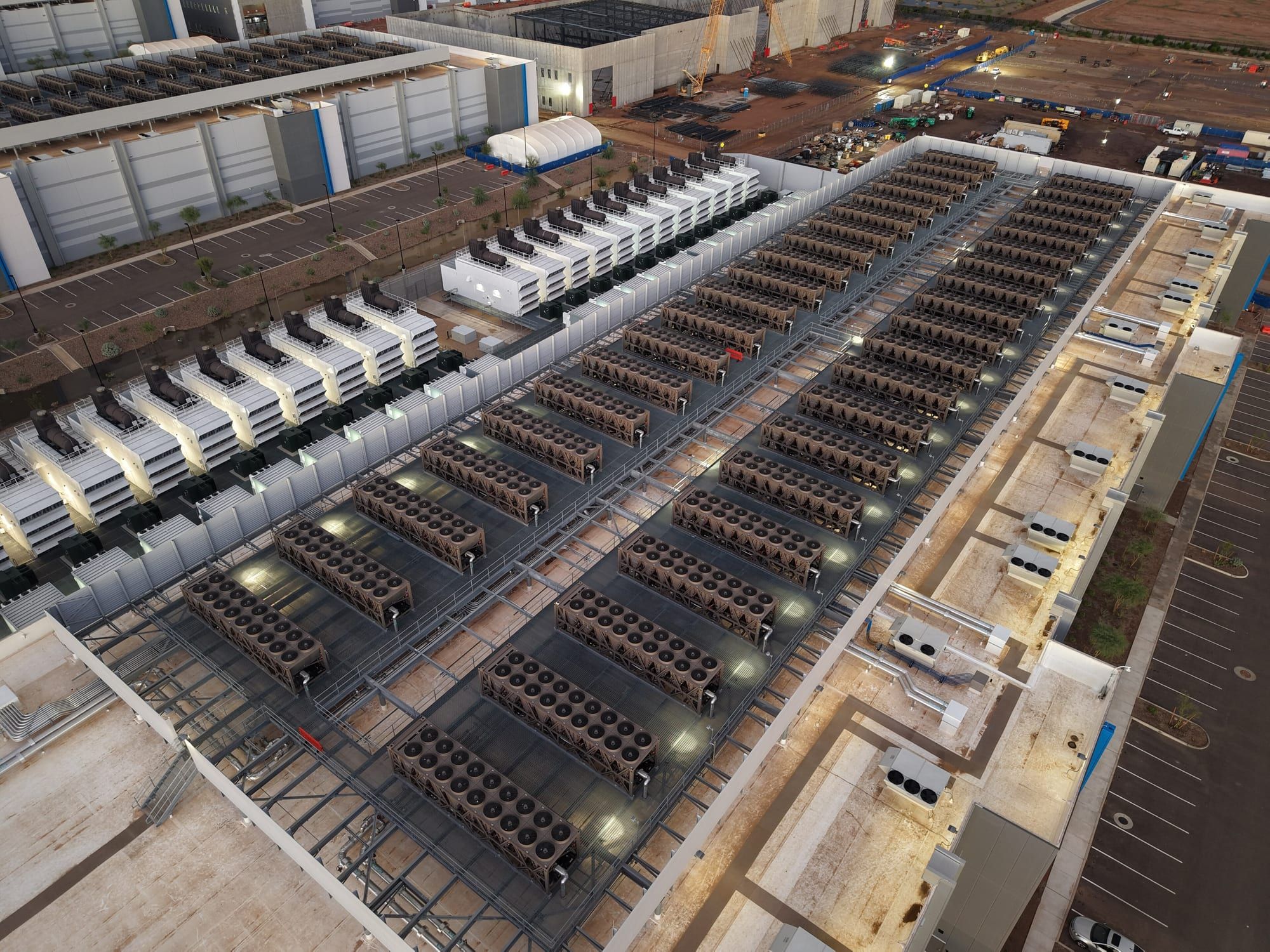 Aerial view of a large data centre complex with rows of cooling units on the roof