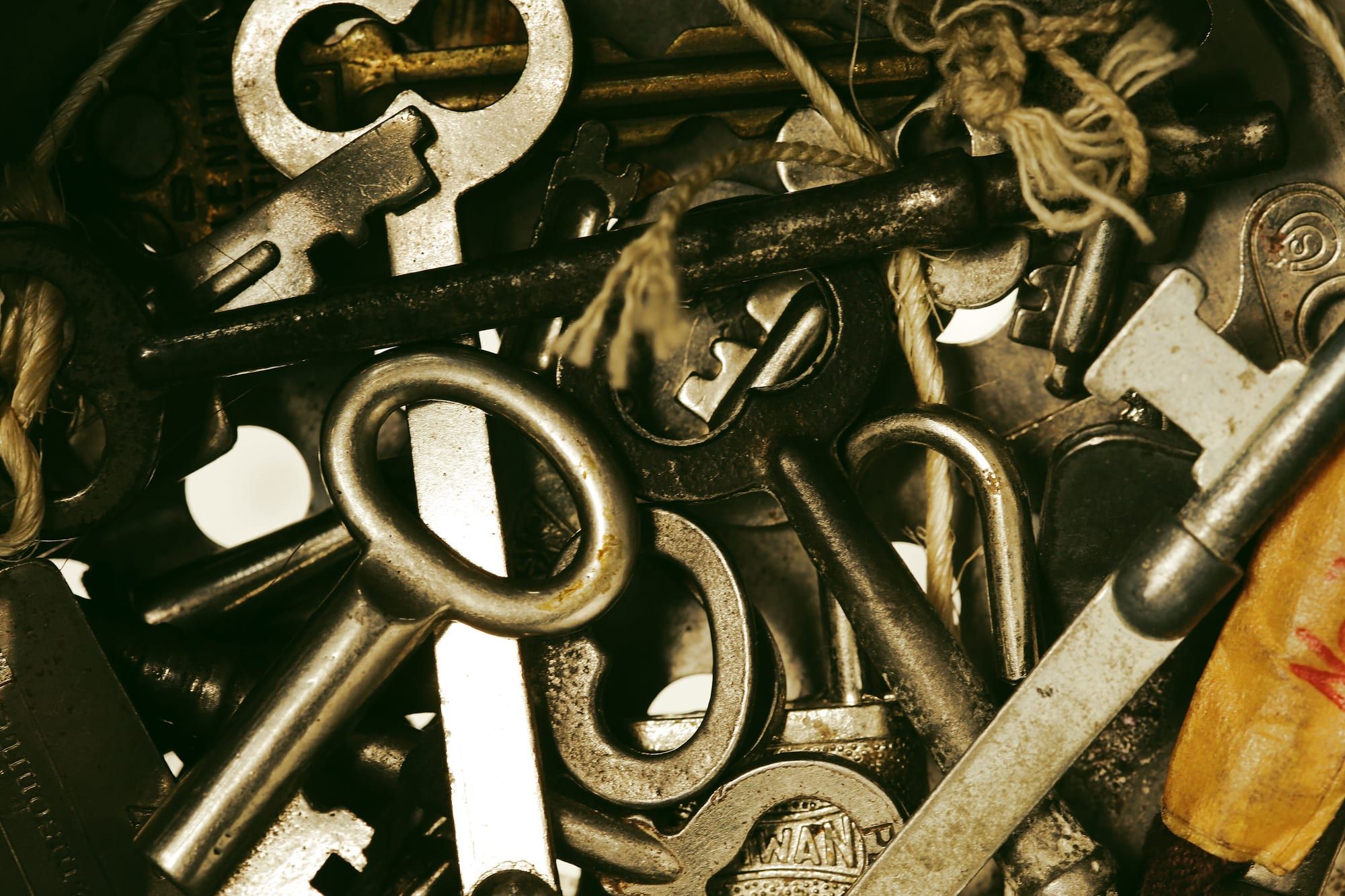 A close-up pile of old metal keys of different shapes